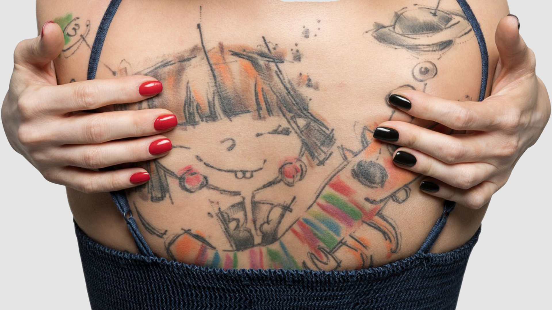Close-up of colorful sketch-style tattoos across a woman's chest, with painted nails framing the design