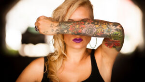 Technician performing laser tattoo removal treatment on a client's arm
