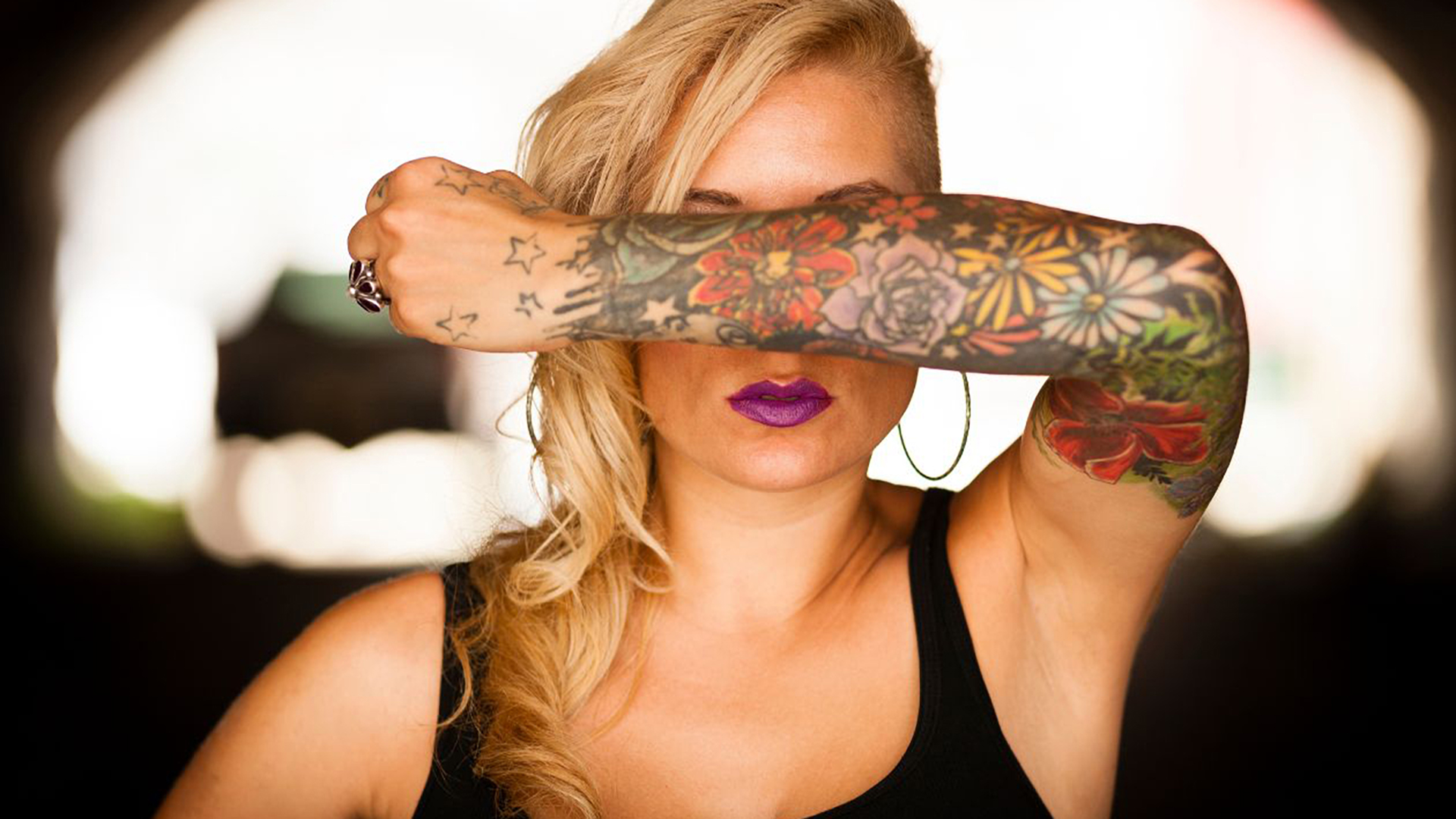 Technician performing laser tattoo removal treatment on a client's arm