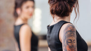 Laser device treating a tattoo on a client's skin during a removal session